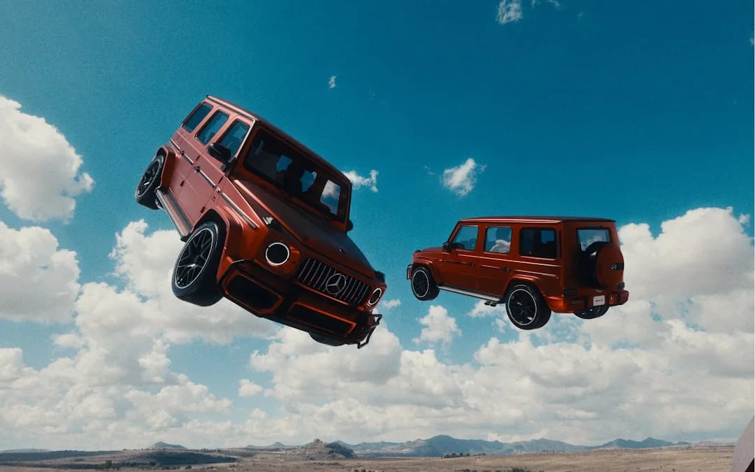 Mercedes-AMG G 63 and Brabus G 800 side by side on a UAE desert road at sunset